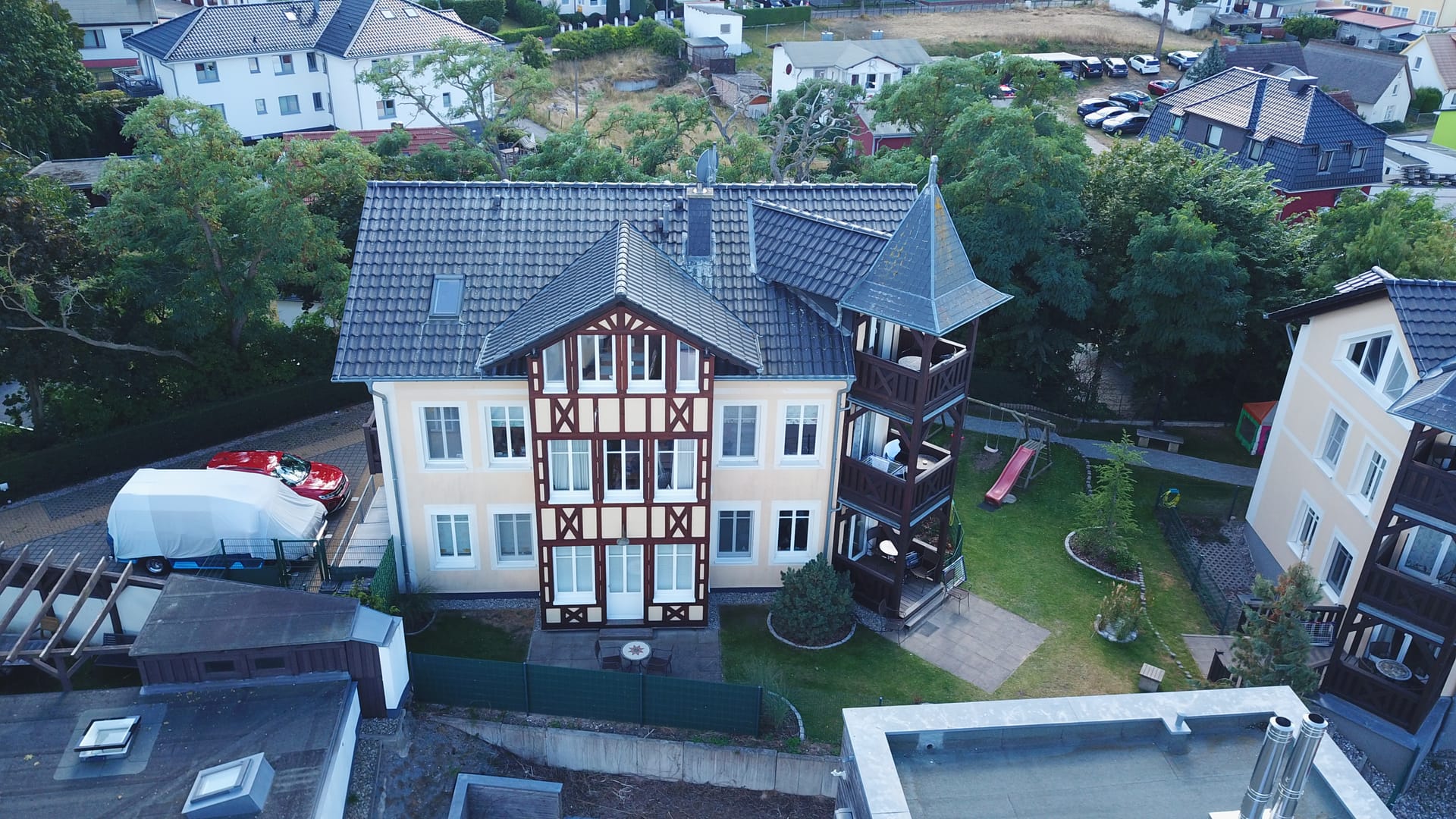 Frontansicht der Ahlbecker Höhe mit umzäuntem Garten und Kinderspielplatz in Ahlbeck