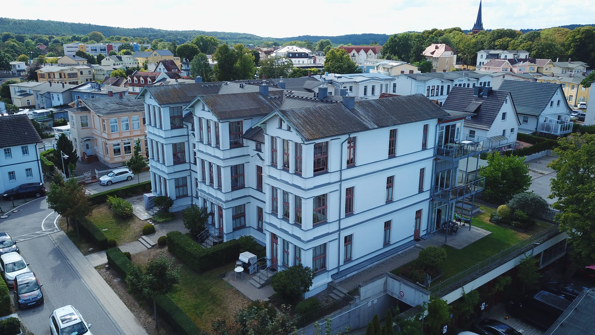 Autorenhaus Ahlbeck: Straßenseite mit Stellplätzen und Nachbarvillen