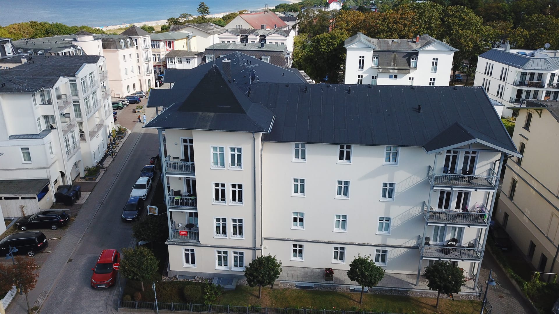 Luftaufnahme des Haus Miramar in Ahlbeck – weiße Bäderstil-Villa mit dunklem Walmdach und Eckturm in der Kurstraße