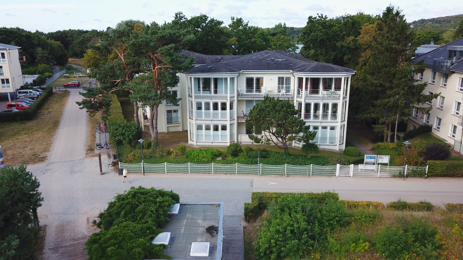Haus Strandoase Heringsdorf von der Strandseite: Frontansicht mit Wintergarten-Erkern und weißem Gartenzaun an der Promenade