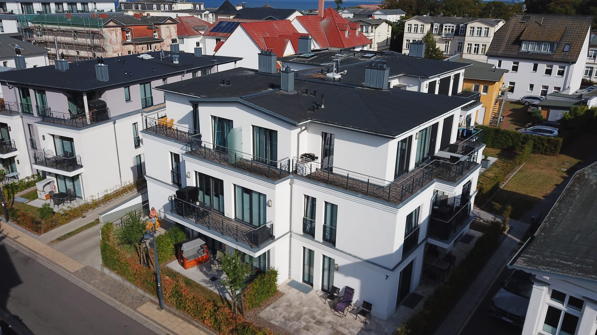 Luftaufnahme des Quartier 7 in Ahlbeck – moderner weißer Neubau mit Balkonen und Dachterrassen in der Karlstraße 7