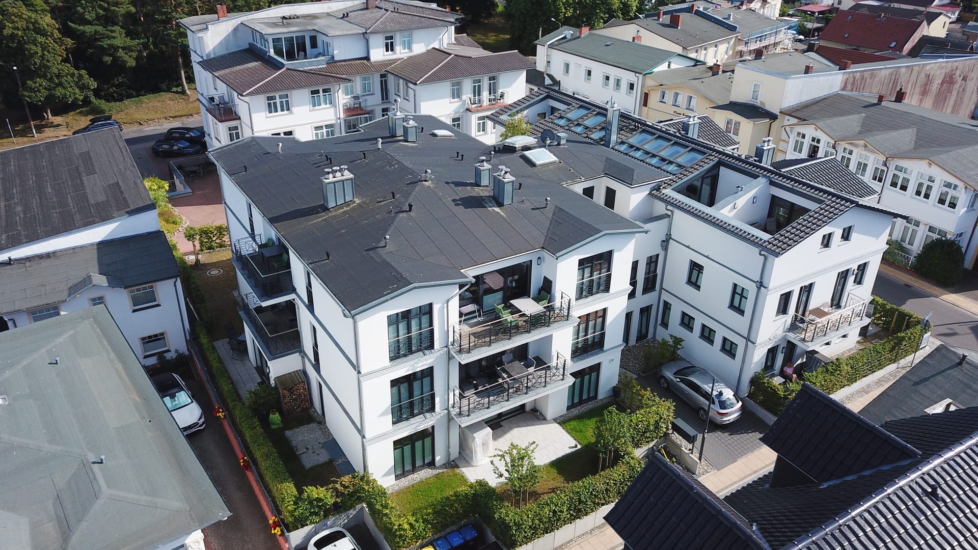 Gartenseite des Quartier Frohsinn Ahlbeck mit möblierten Balkonen und Terrassen der Ferienwohnungen