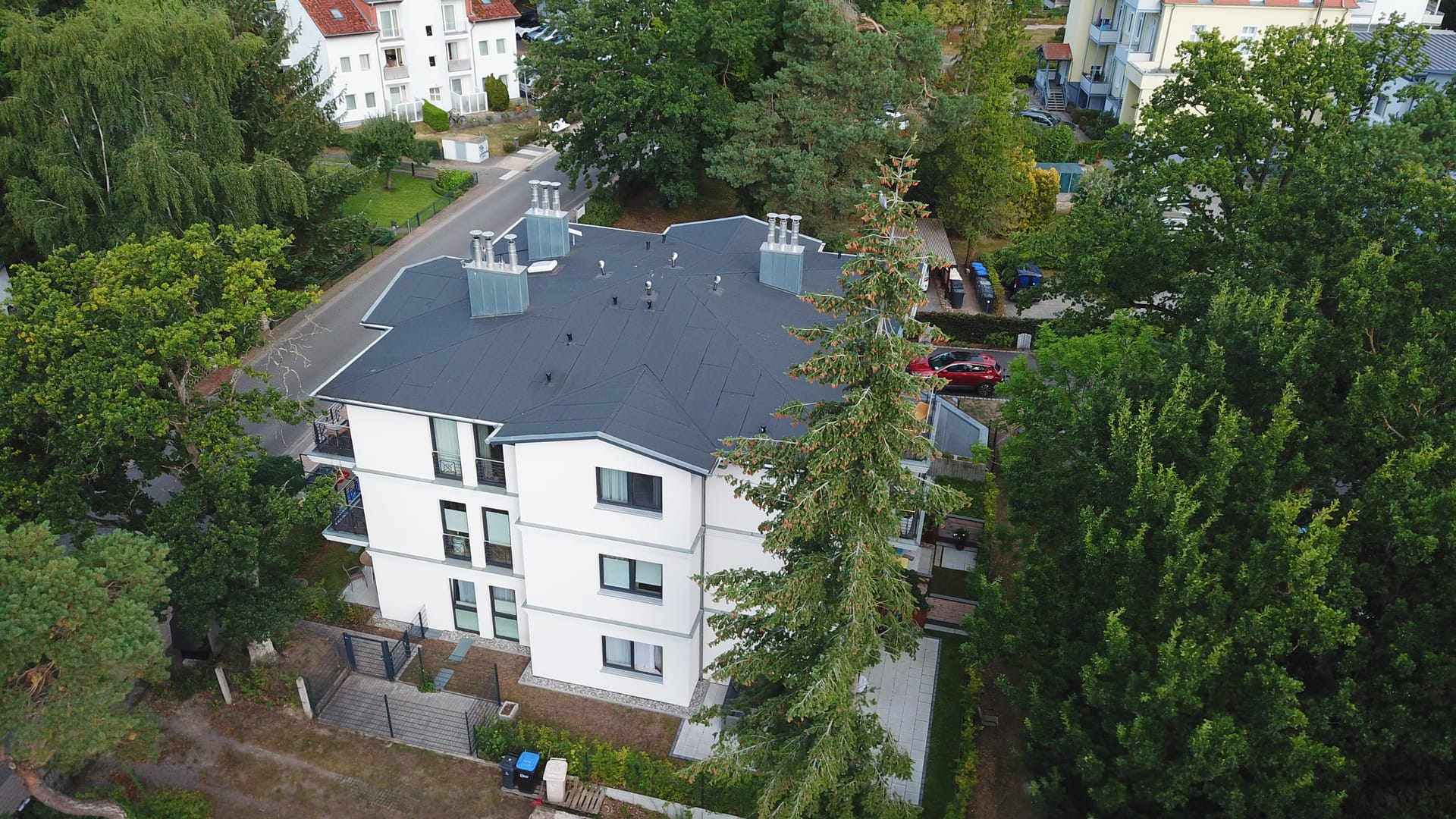 Quartier Maxim Heringsdorf aus der Vogelperspektive: Walmdach mit markanten Schornsteinen und Terrassen im Erdgeschoss