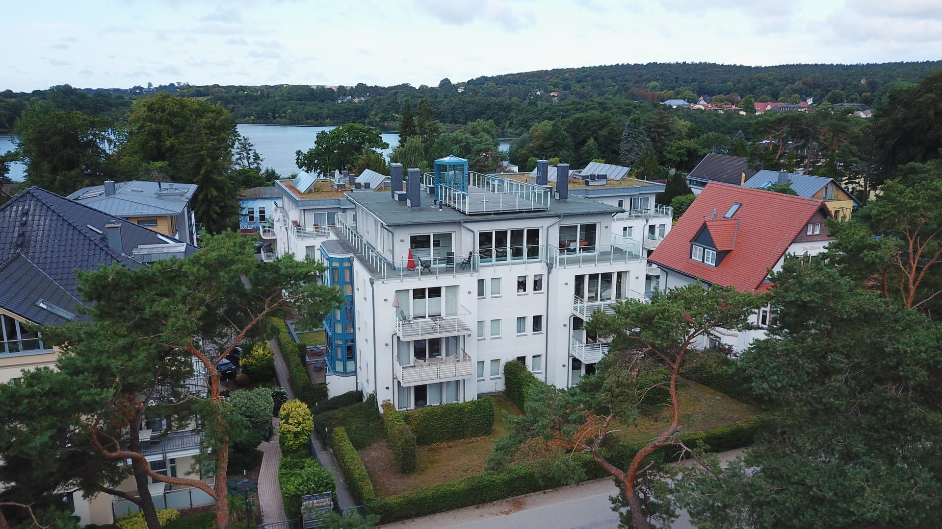 Promenadenseitiges Haus der Seeresidenzen Bansin mit Balkonen und Dachterrassen, rechts die rote Villa der Anlage