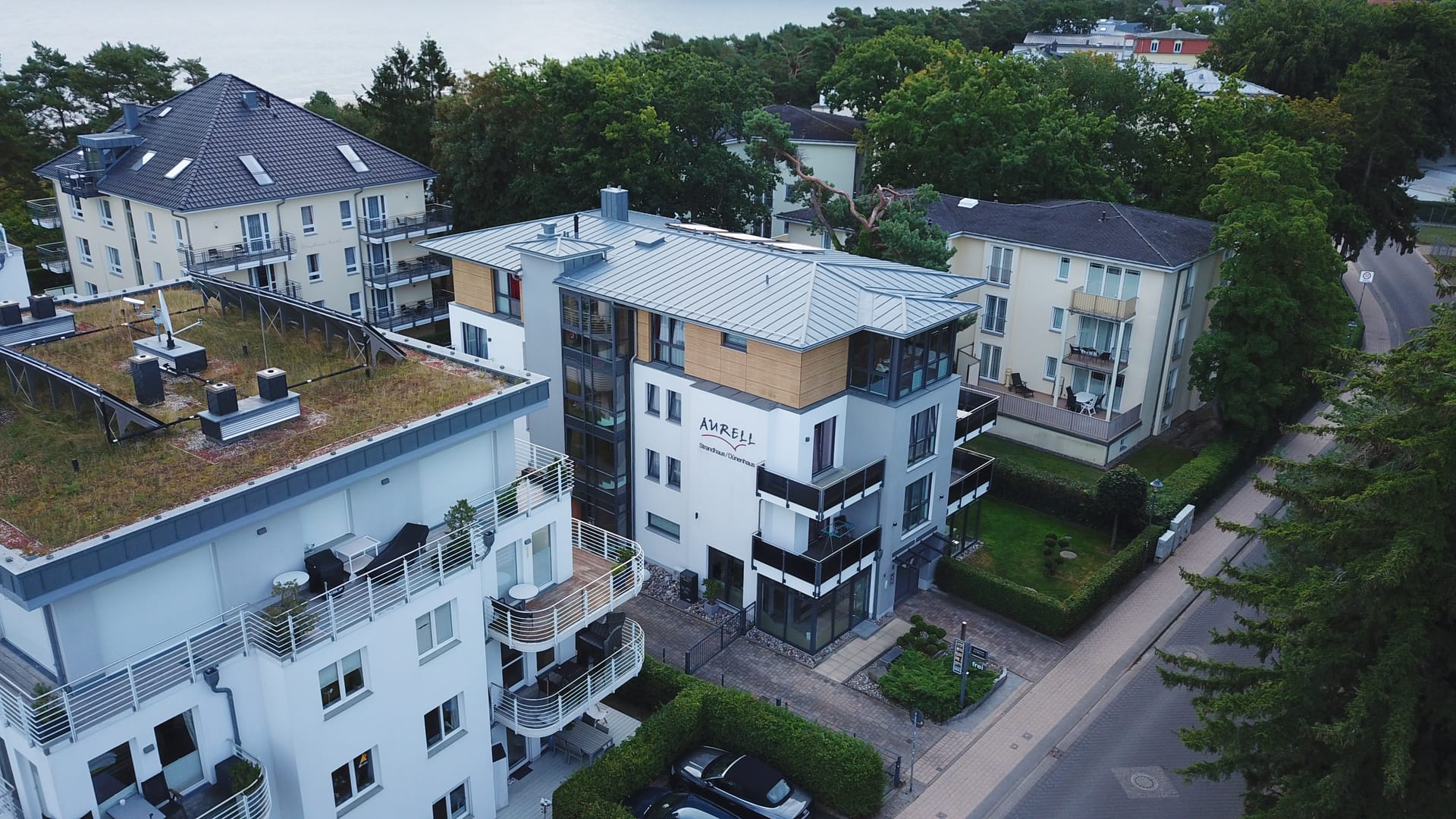 Dünenhaus Aurell von der Straßenseite mit gläsernem Treppenhaus und Balkonen