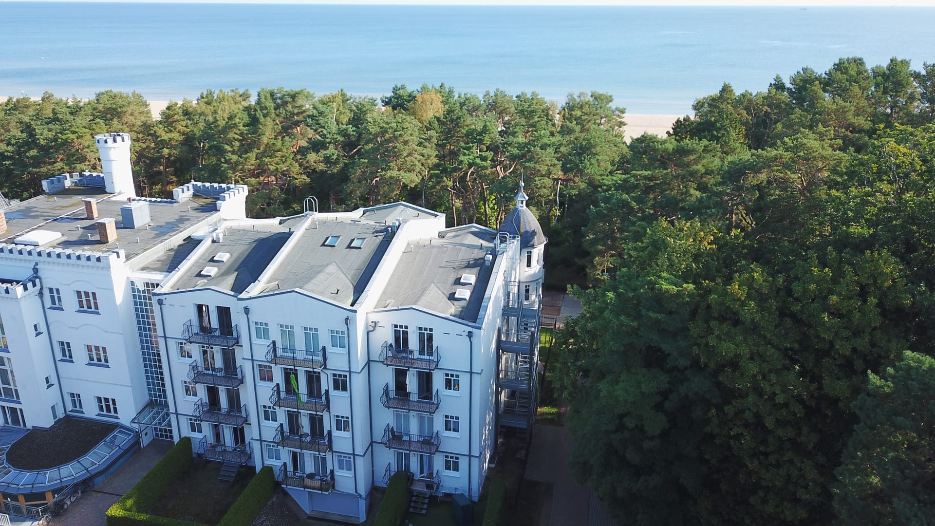 Blick über den Balkonflügel der Tannenburg Ahlbeck auf Küstenwald, Strand und Ostsee