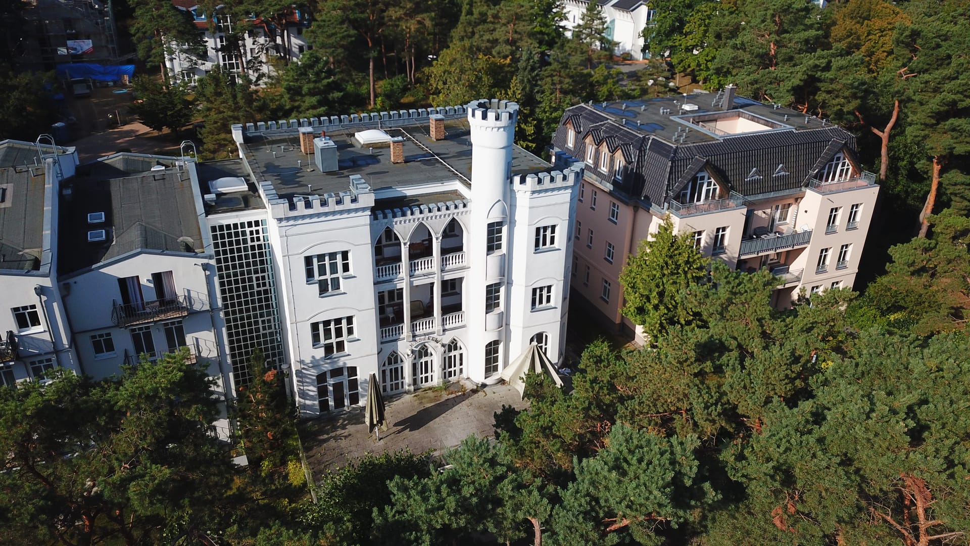 Tannenburg Ahlbeck aus der Luft – schlossartige Fassade mit Spitzbogenfenstern zwischen Kiefern