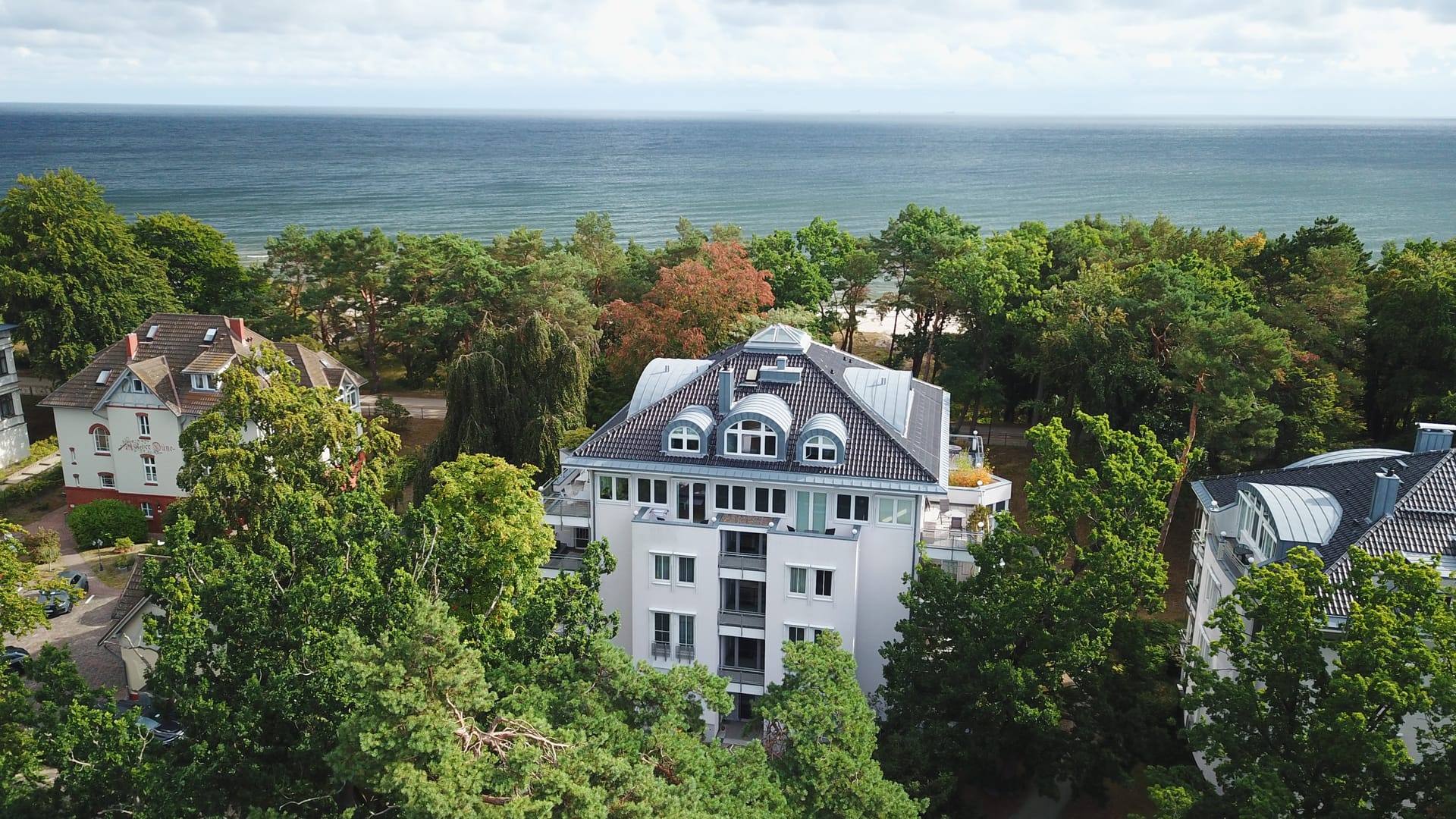 Luftaufnahme der Villa Darja Heringsdorf – weiße Villa in erster Reihe, dahinter Strand und Ostsee