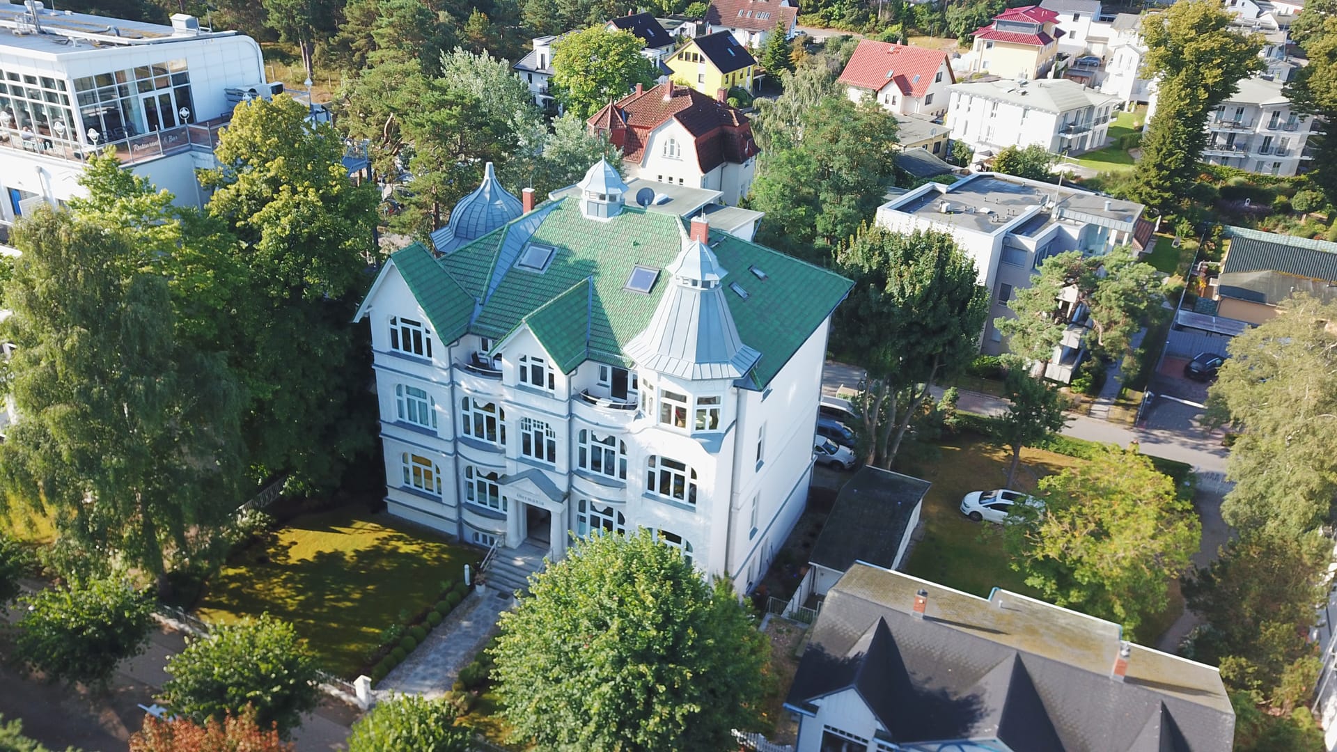 Luftbild der Villa Germania mit Blick über die Dächer und Gärten des Seebads Ahlbeck