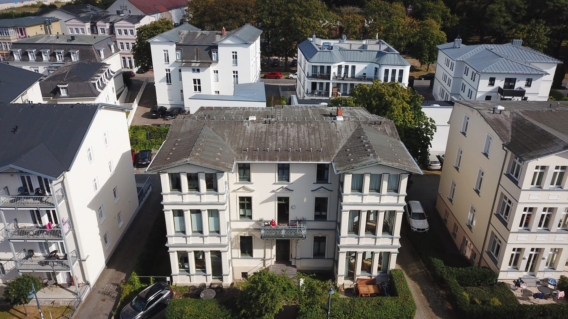 Die Villa Goodewind in Ahlbeck aus der Luft: Bädervilla an der Neuen Straße mit Balkon und Veranden, dahinter die Dächer des Seebads