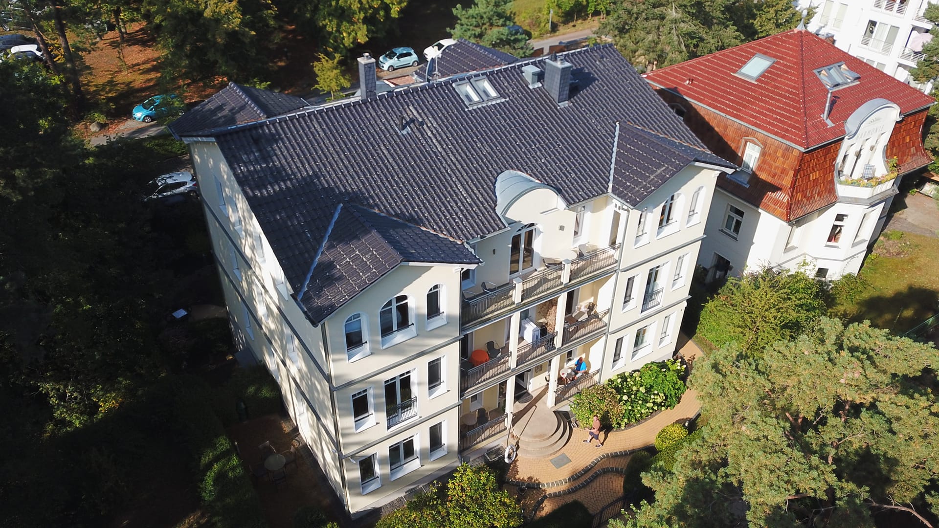 Villa Lebensart in Ahlbeck von oben: helle Fassade, Türmchen und Garten mit Südterrasse
