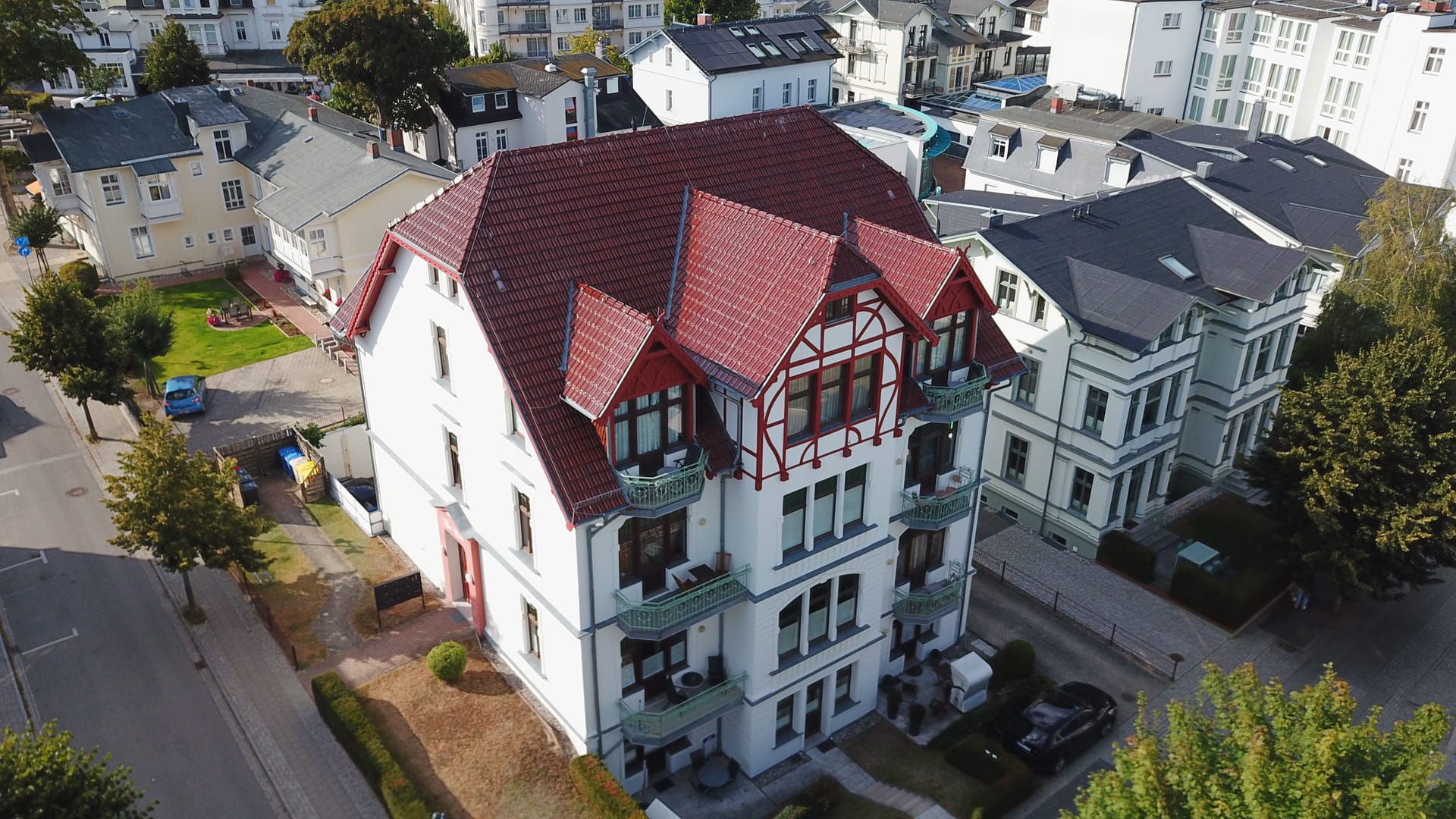 Villa Medici Ahlbeck von oben: weiße Bäderstil-Fassade mit schmiedeeisernen Balkonen an der Kurstraße
